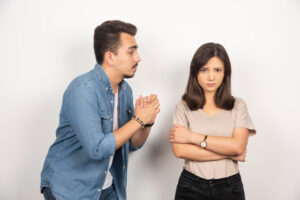 Couple showing frustrated body language during conversation with eye-rolling gesture