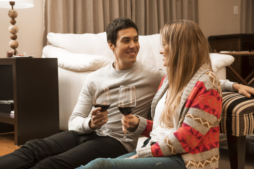 happy couple enjoying wine together at home and connecting emotionally