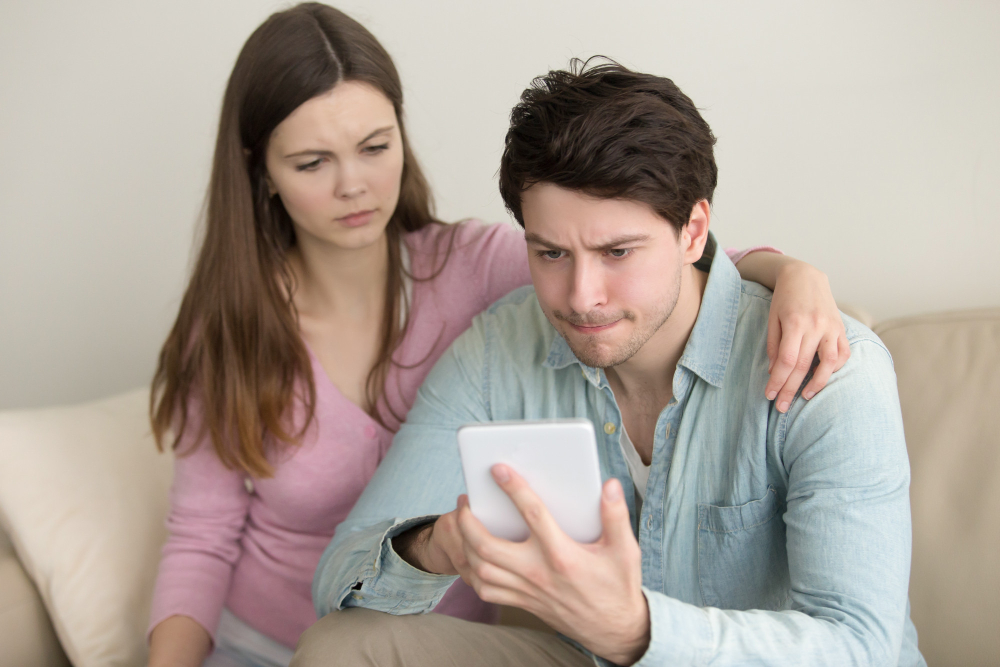 Concerned couple sitting together while discussing difficult relationship issues and emotional stress caused by avoiding unresolved topics in therapy.