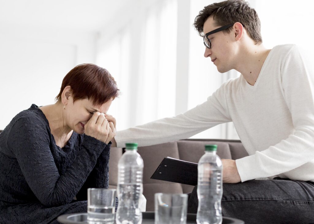 Therapist supporting an emotionally overwhelmed person during relationship counseling session about emotional flooding and conflict communication