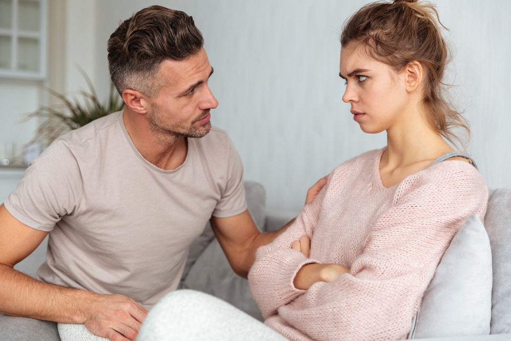 Partner offering an apology during a tense relationship conversation while the other partner remains emotionally guarded, illustrating how ineffective apologies can leave underlying relationship issues unresolved.