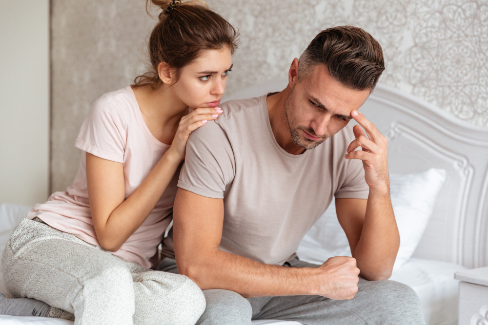 Couple sitting together on a bed during a difficult moment, with one partner offering support while the other appears emotionally distressed, representing the process of rebuilding connection and reversing emotional neglect in marriage