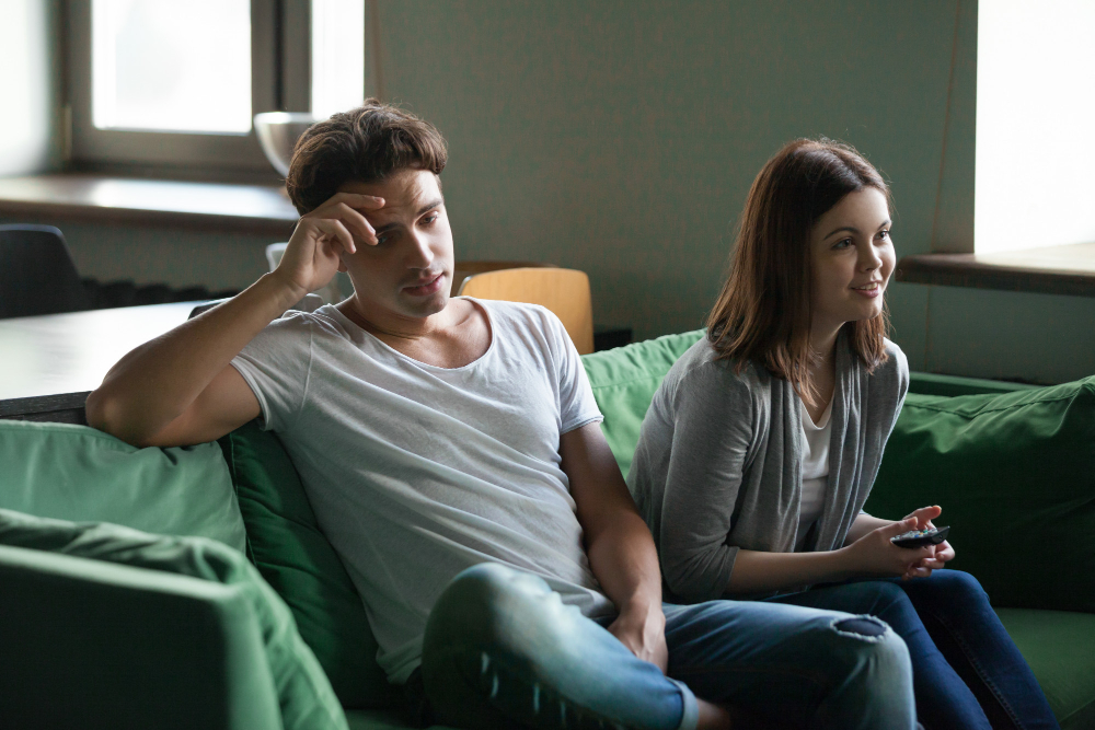Couple sitting together with visible tension and emotional disconnect, illustrating signs of poor emotional regulation, stress, miscommunication, and relationship challenges during difficult interactions.