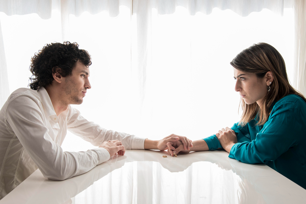 Couple holding hands during a serious conversation, illustrating how commitment issues can improve over time through trust, communication, and emotional growth.