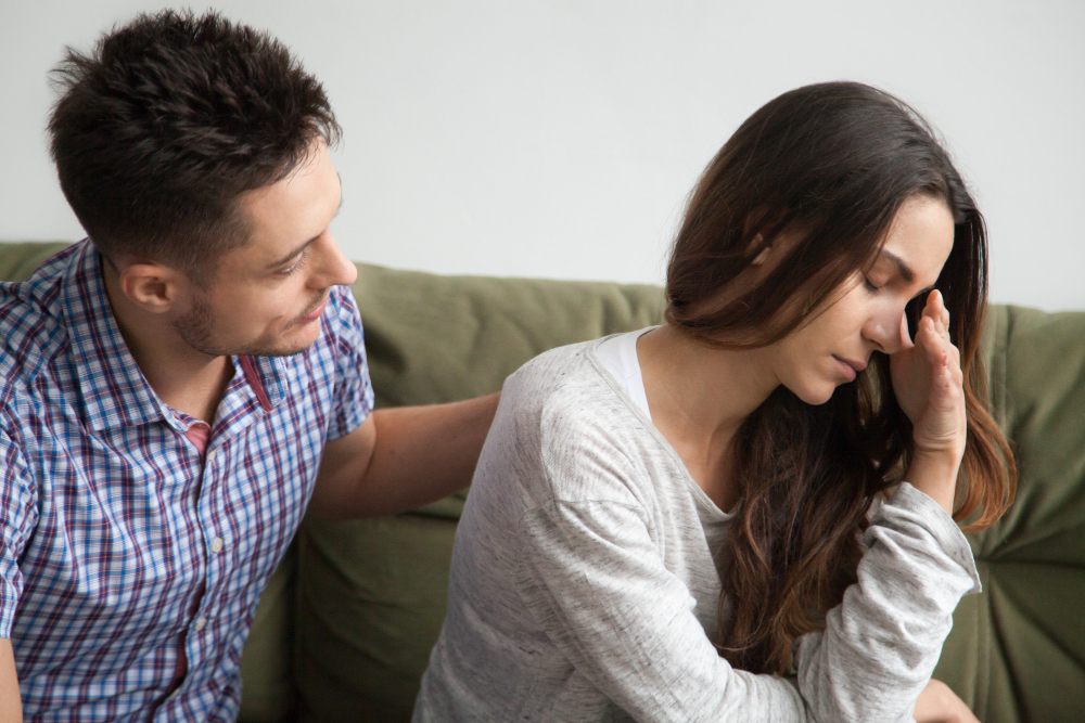 Partner comforting a spouse who has emotionally withdrawn, illustrating how unresolved childhood trauma can lead to avoidance, emotional disconnection, and communication difficulties in marriage.